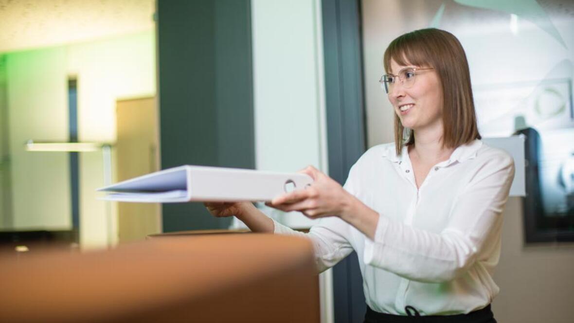 ZAWI Treuhand - Kollegin mit Dokumenten